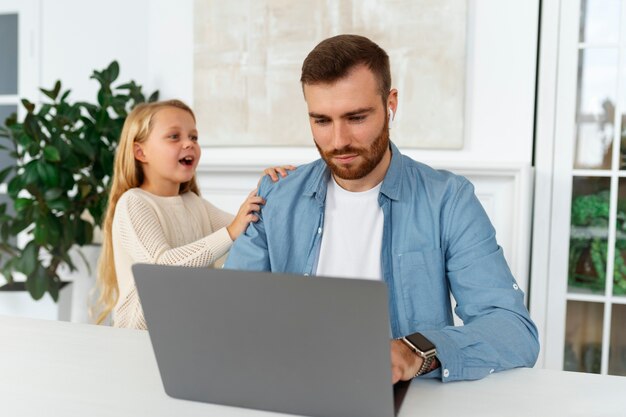 Foto gratuita padre de tiro medio trabajando de forma remota