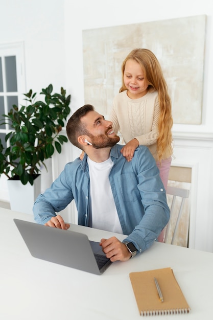 Foto gratuita padre de tiro medio trabajando de forma remota