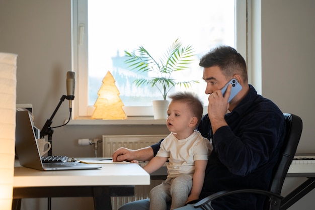 Padre de tiro medio trabajando con un niño en casa