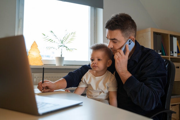 Padre de tiro medio trabajando con un niño en casa