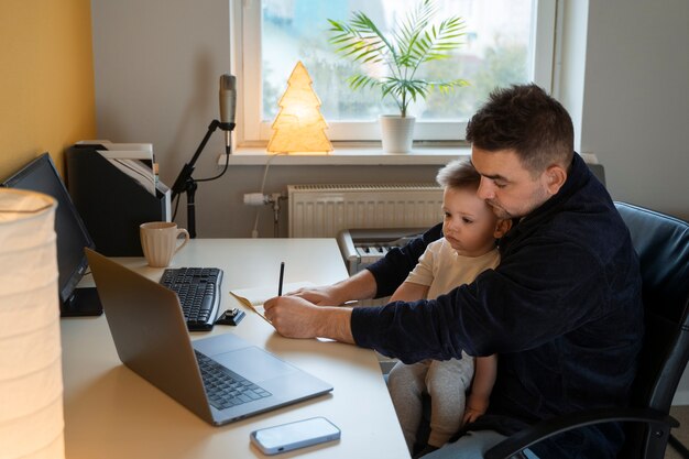 Padre de tiro medio trabajando con un niño en casa