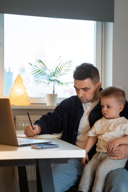 Foto gratuita padre de tiro medio trabajando con un niño en casa