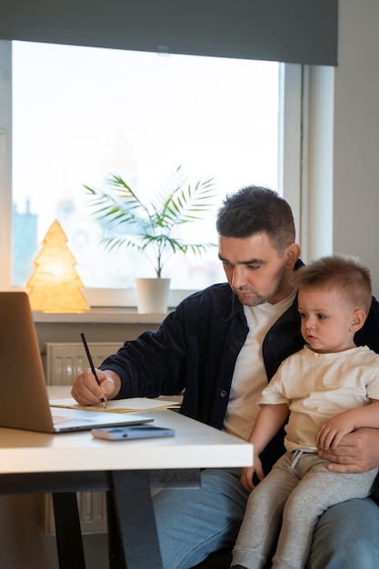 Padre de tiro medio trabajando con un niño en casa