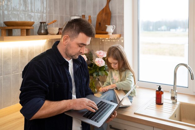 Padre de tiro medio trabajando con un niño en casa