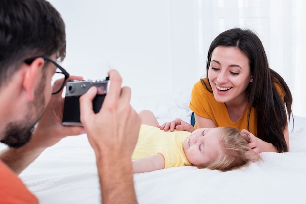 Padre tomando foto de madre con bebé