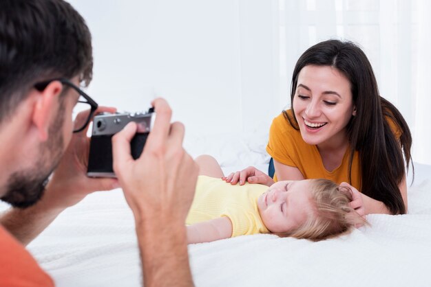 Padre tomando foto de madre con bebé