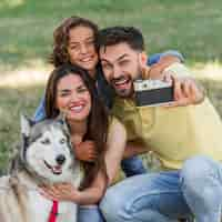 Foto gratuita padre tomando selfie de la familia y el perro mientras está en el parque