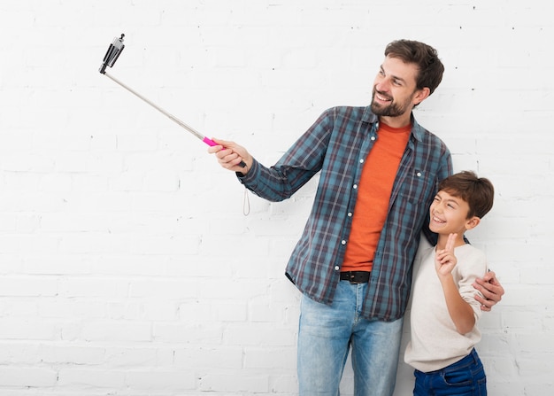 Foto gratuita padre tomando una selfie con su niño pequeño