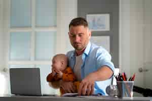 Foto gratuita padre trabajando desde casa tratando de equilibrar la vida familiar con el niño y el trabajo
