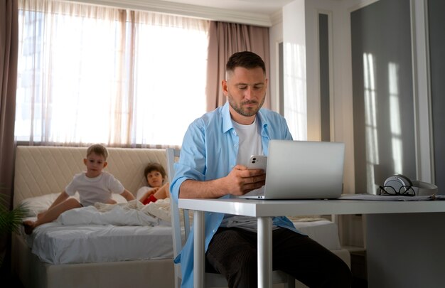 Padre trabajando desde casa tratando de equilibrar la vida familiar con el niño y el trabajo