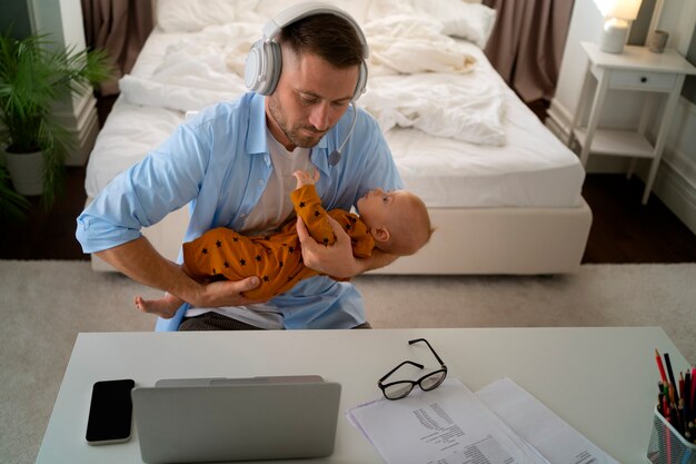 Padre trabajando desde casa tratando de equilibrar la vida familiar con el niño y el trabajo