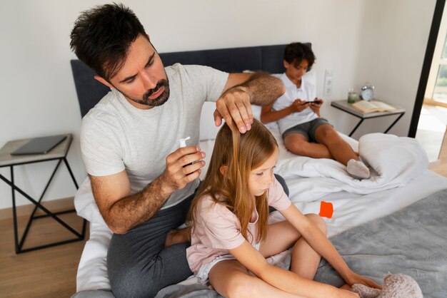 Padre usando tratamiento para piojos alto ángulo