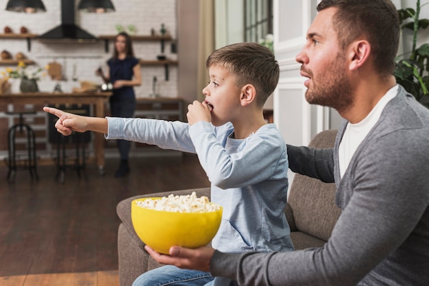 Foto gratuita padre viendo una película con hijo