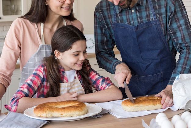 Foto gratuita padres de alto ángulo enseñando a niña a cocinar