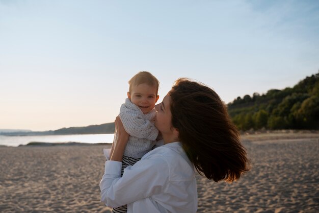 Padres con un bebé en la playa al atardecer