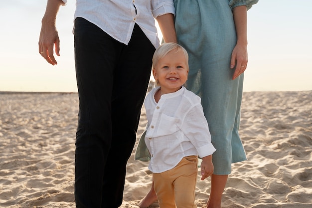 Foto gratuita padres con un bebé en la playa al atardecer