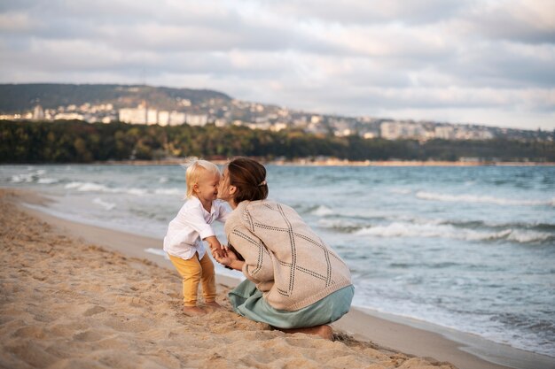 Foto gratuita padres con un bebé en la playa al atardecer