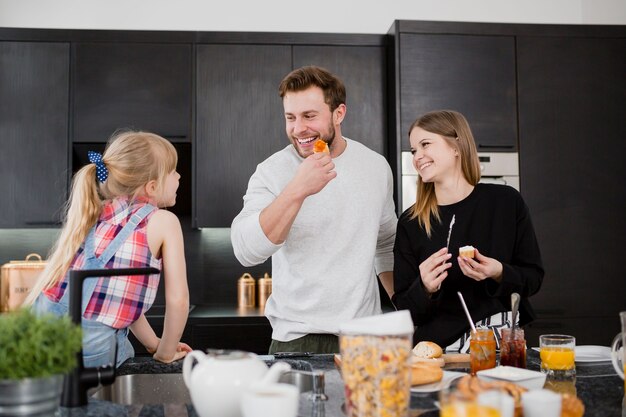 Padres cocinando cerca de la hija