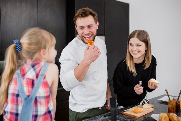 Padres cocinando y comunicándose con su hija