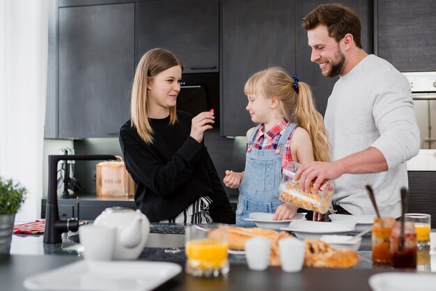 Padres cocinando el desayuno para su hija