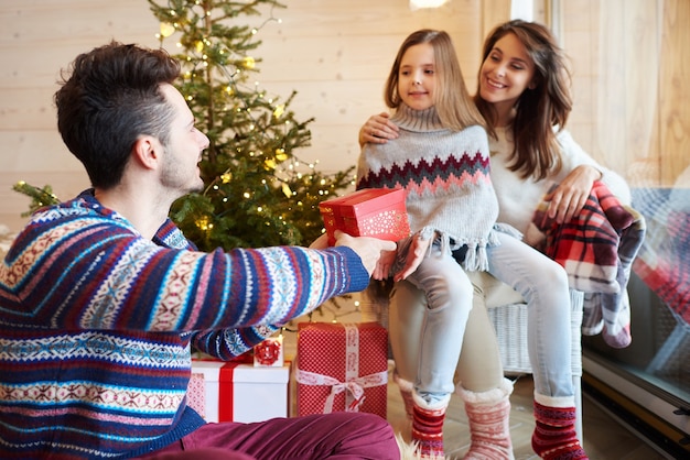 Padres e hija intercambiando regalos.