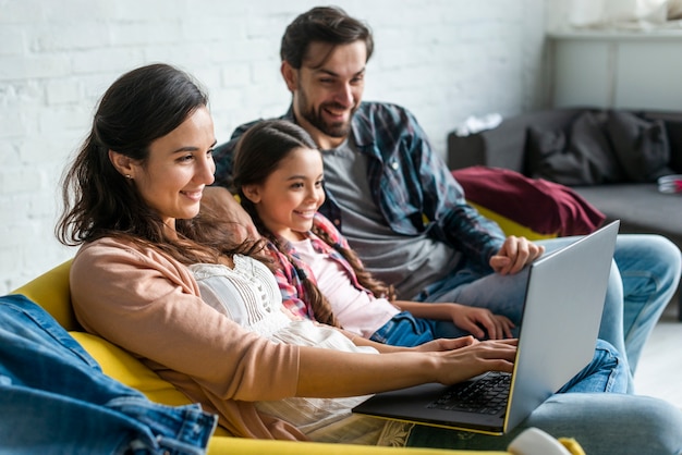 Padres e hija usando una computadora portátil