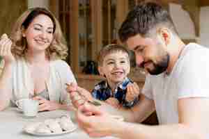 Foto gratuita padres e hijo comiendo dulces para el desayuno