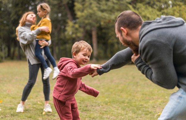 Foto gratuita padres e hijos jugando juntos afuera.