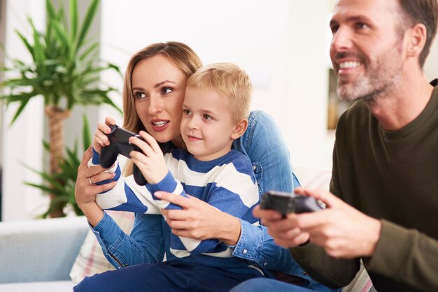 Padres emocionales e hijo jugando videojuegos