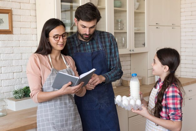 Padres enseñando a niña a cocinar