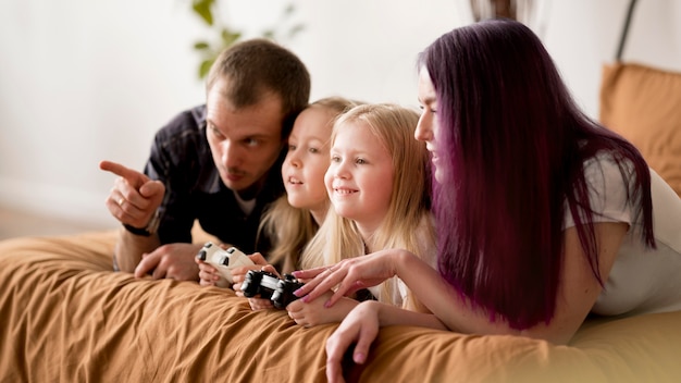 Padres enseñando a las niñas a jugar con joystick