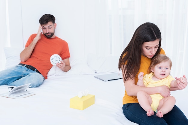 Padres estresados mientras sostienen al bebé