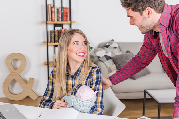 Padres felices con el bebé mirando el uno al otro