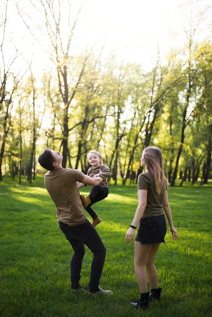 Foto gratuita padres felices con hijo en la naturaleza