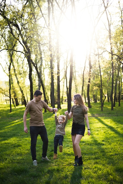 Foto gratuita padres felices con hijo en la naturaleza