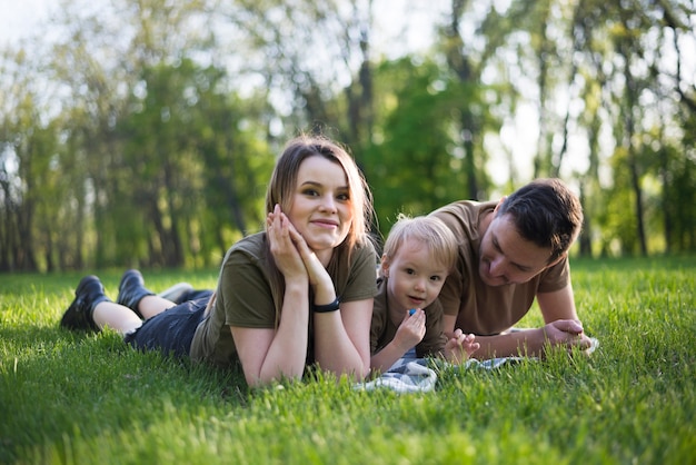 Foto gratuita padres felices con hijo en la naturaleza