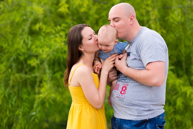 Foto gratuita padres felices con hijo en la naturaleza