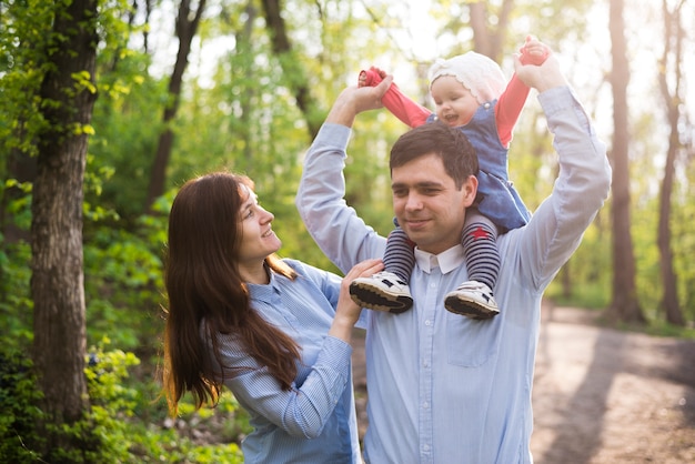 Foto gratuita padres felices con hijo en la naturaleza