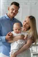 Foto gratuita padres felices de tiro medio con bebé