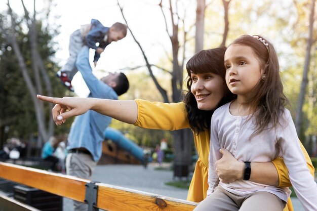 Padres felices de tiro medio con niños en el parque