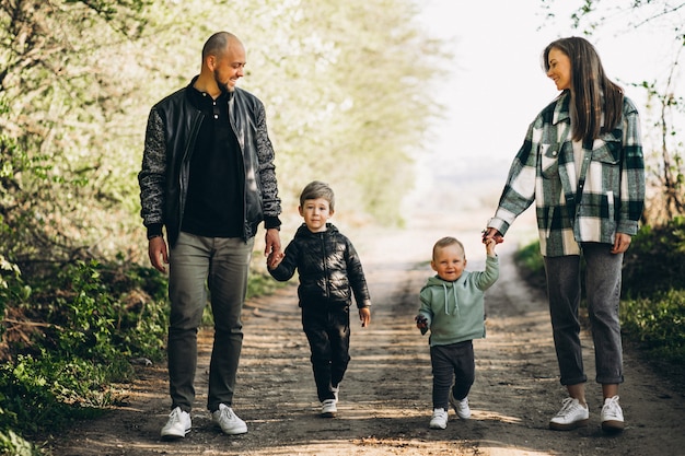 Padres jóvenes con sus hijos en el bosque.