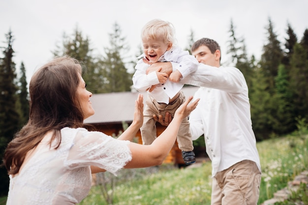 Los padres juegan con su pequeño hijo rubio