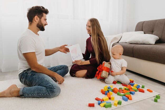 Padres jugando con el bebé en casa