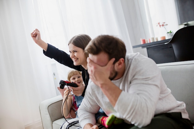 Padres jugando videojuegos en el sofá