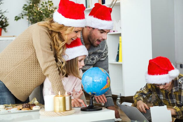 Padres mirando a su hijo abrir regalos