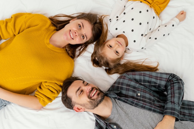 Los padres y el niño de tiro medio en la cama vista superior