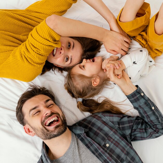 Los padres y el niño de tiro medio en la cama vista superior