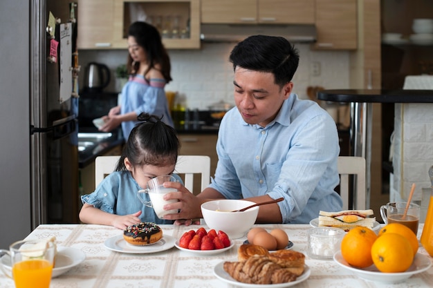 Los padres y el niño de tiro medio en la cocina