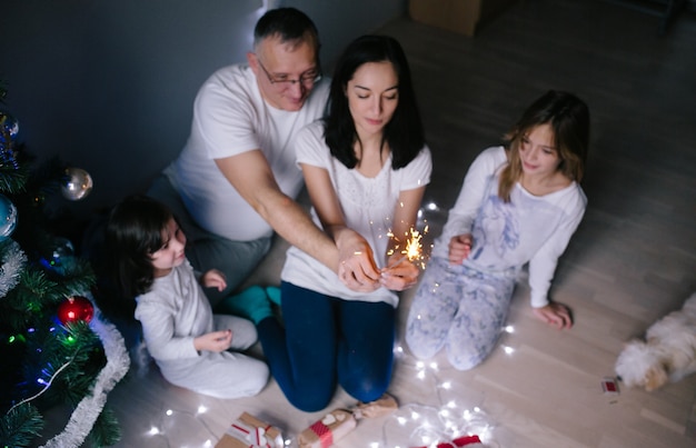 Padres con los niños en el árbol de Navidad