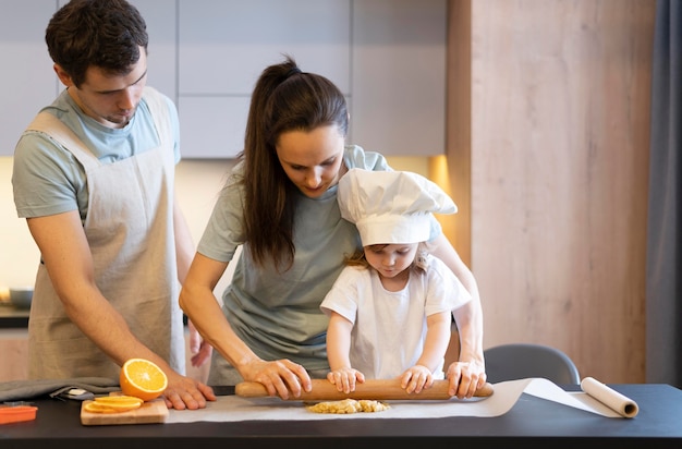 Padres y niños de tiro medio cocinando